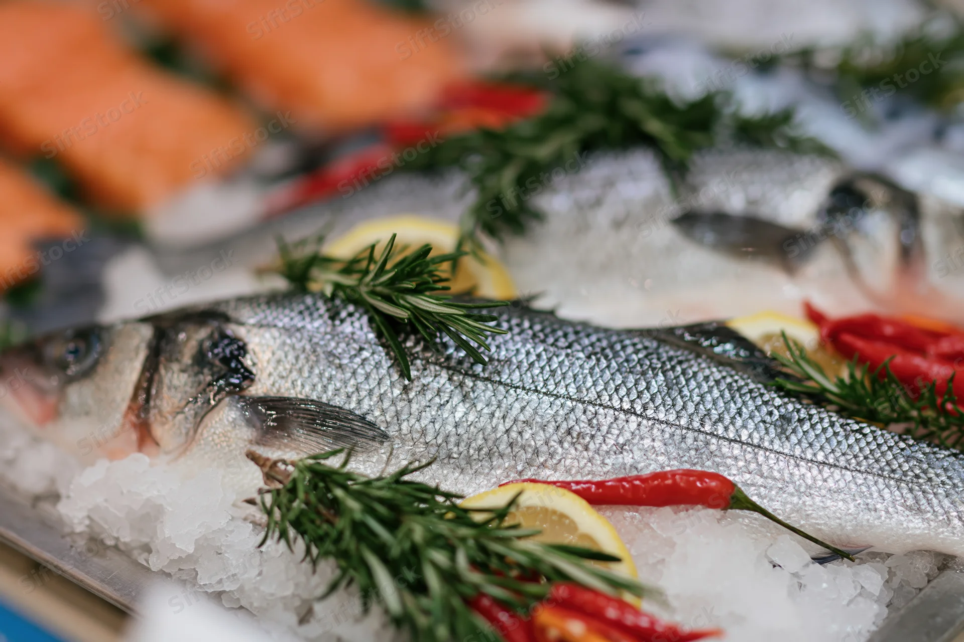Whole sea bass on crushed ice with rosemary and lemon at a fish market