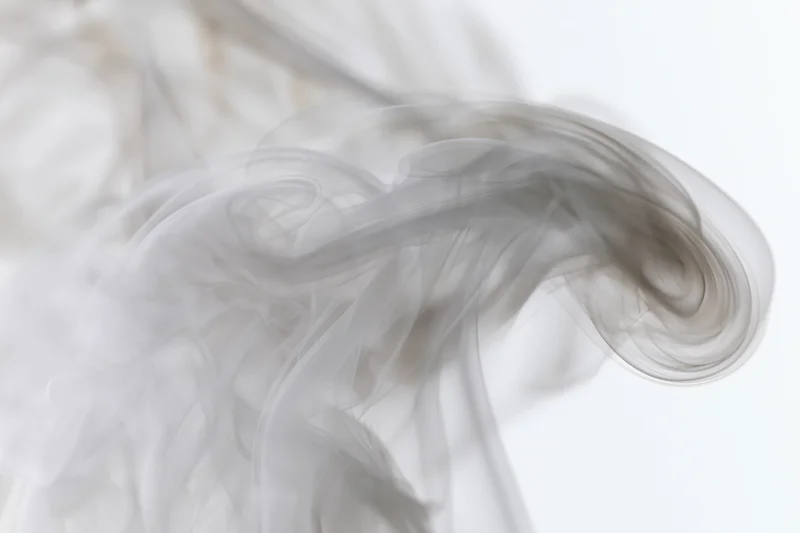Wispy smoke curling upward against a plain white background