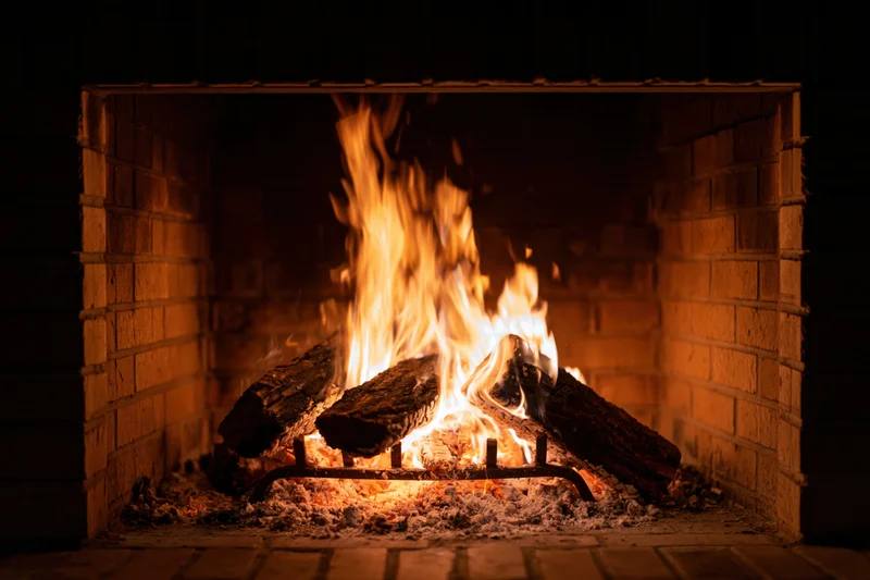 Wood logs burning in a brick fireplace at night