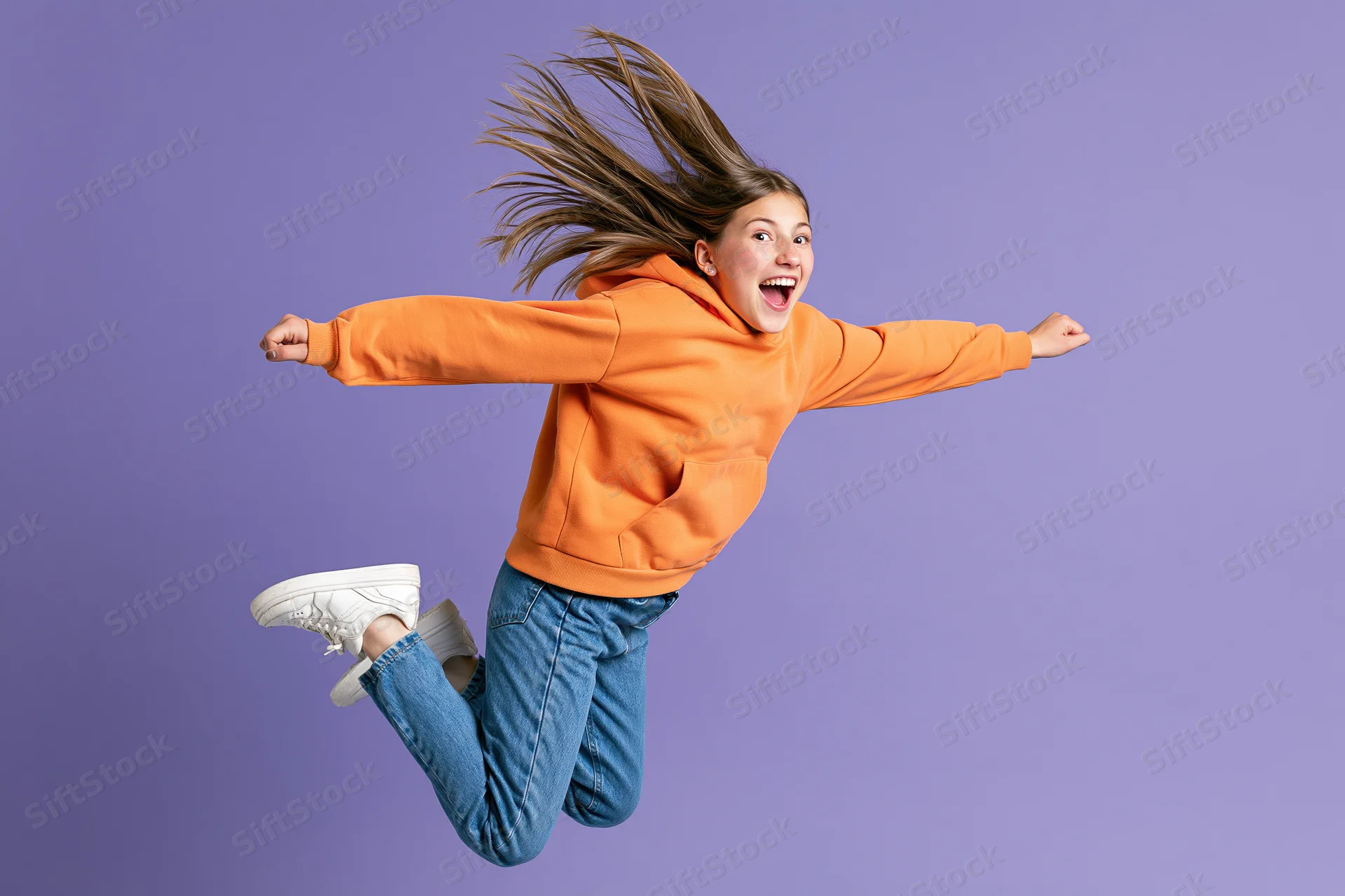 Girl jumping midair with arms outstretched against purple background