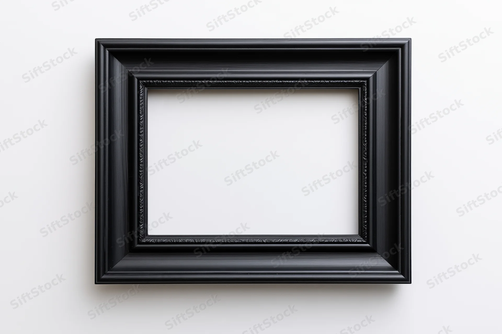 Black rectangular picture frame with molded edges hanging on white wall