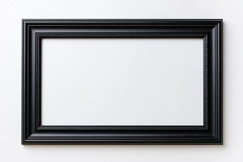 Black rectangular picture frame with ornate molding hanging on a white wall, empty and ready for display