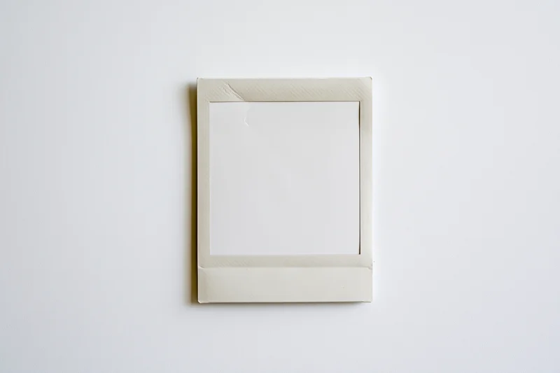 Blank instant film print lying flat on white surface