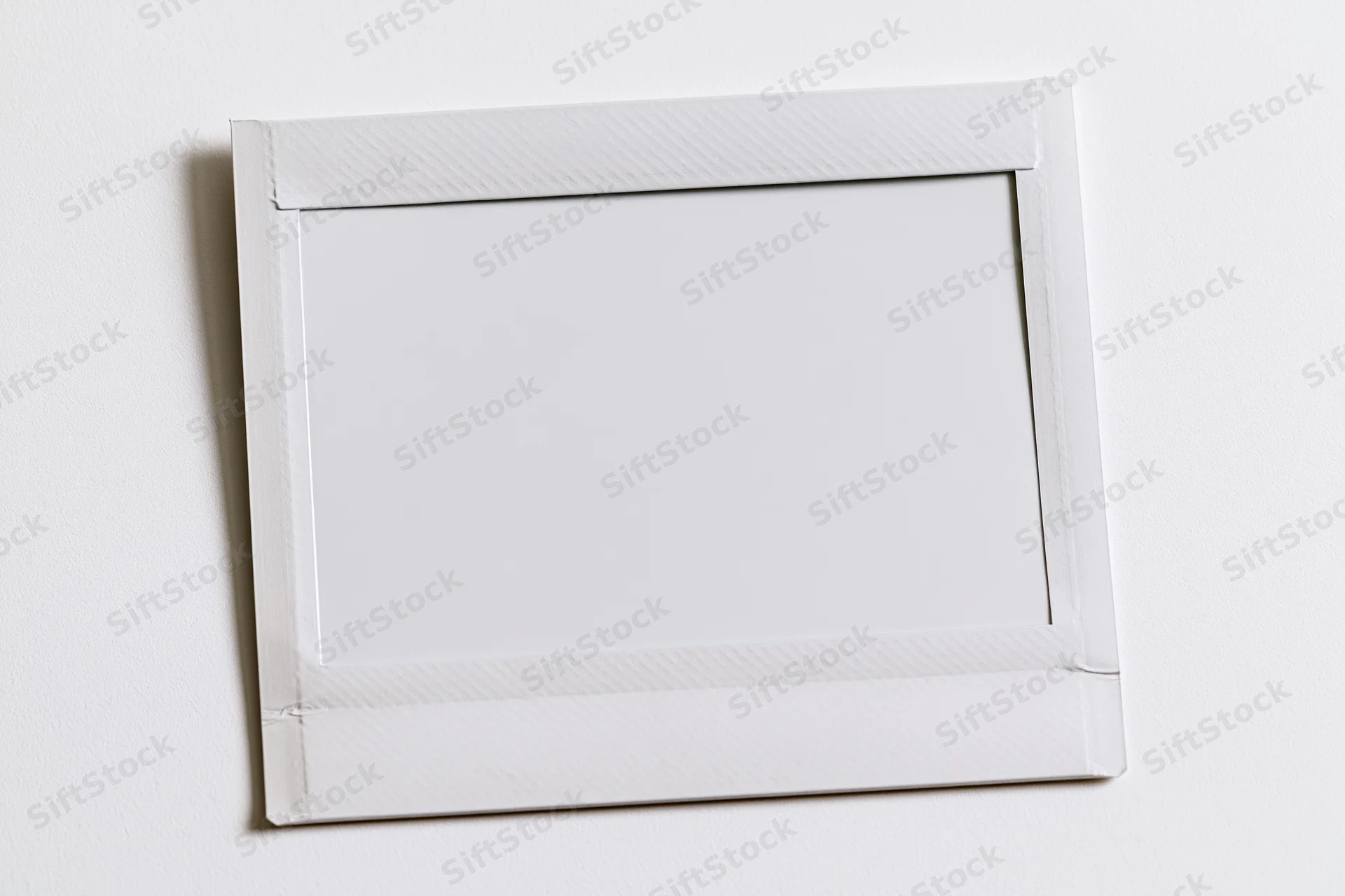 Blank instant film print lying flat on white surface