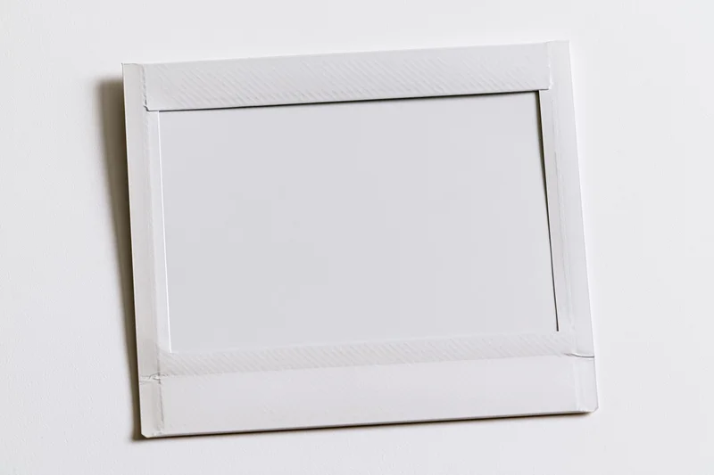 Blank instant film print lying flat on white surface