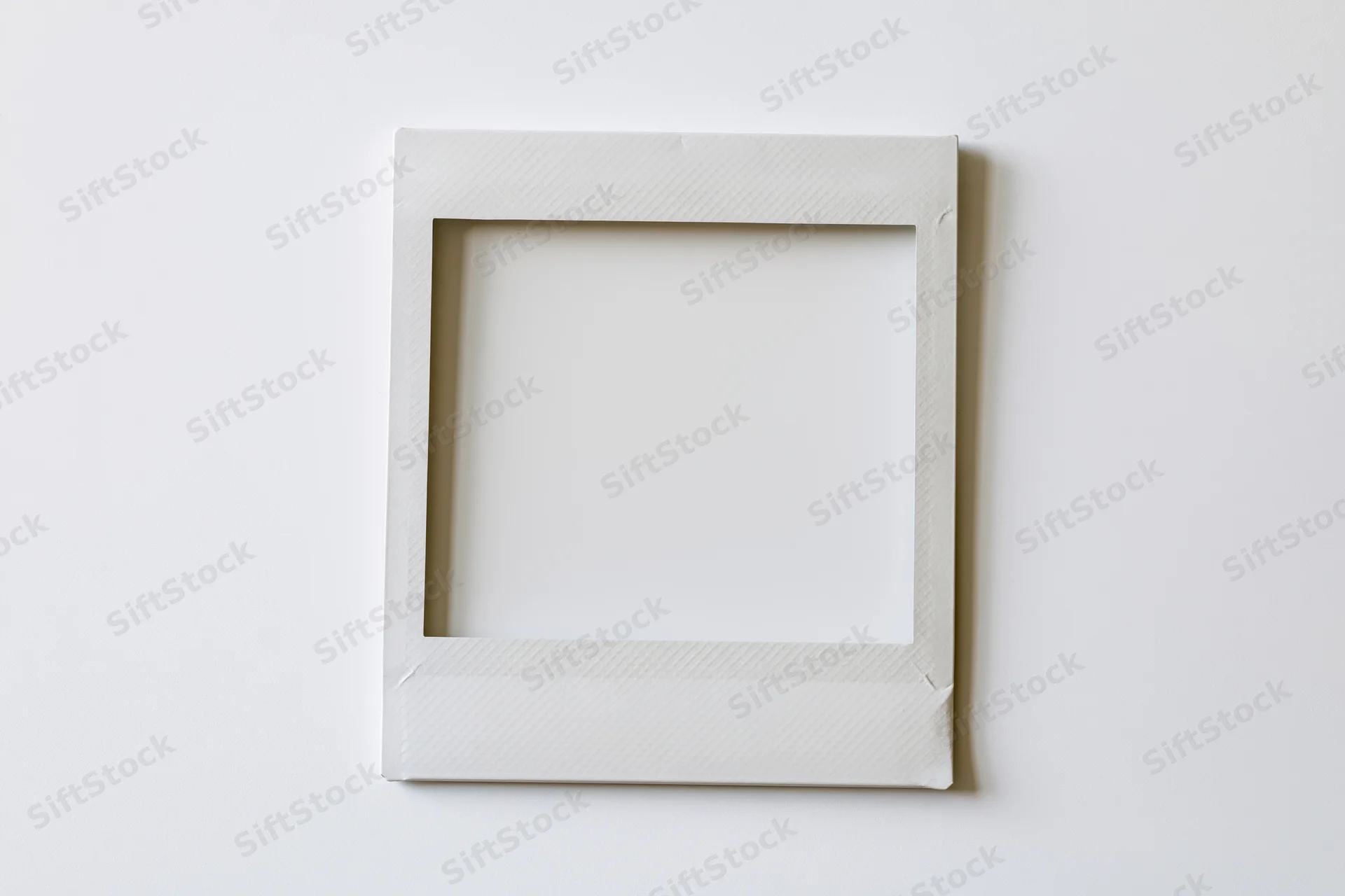 Blank instant film print lying flat on white surface