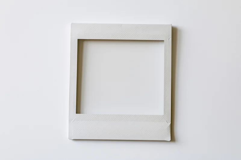 Blank instant film print lying flat on white surface
