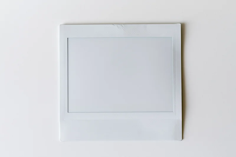 Blank instant film print lying flat on white surface