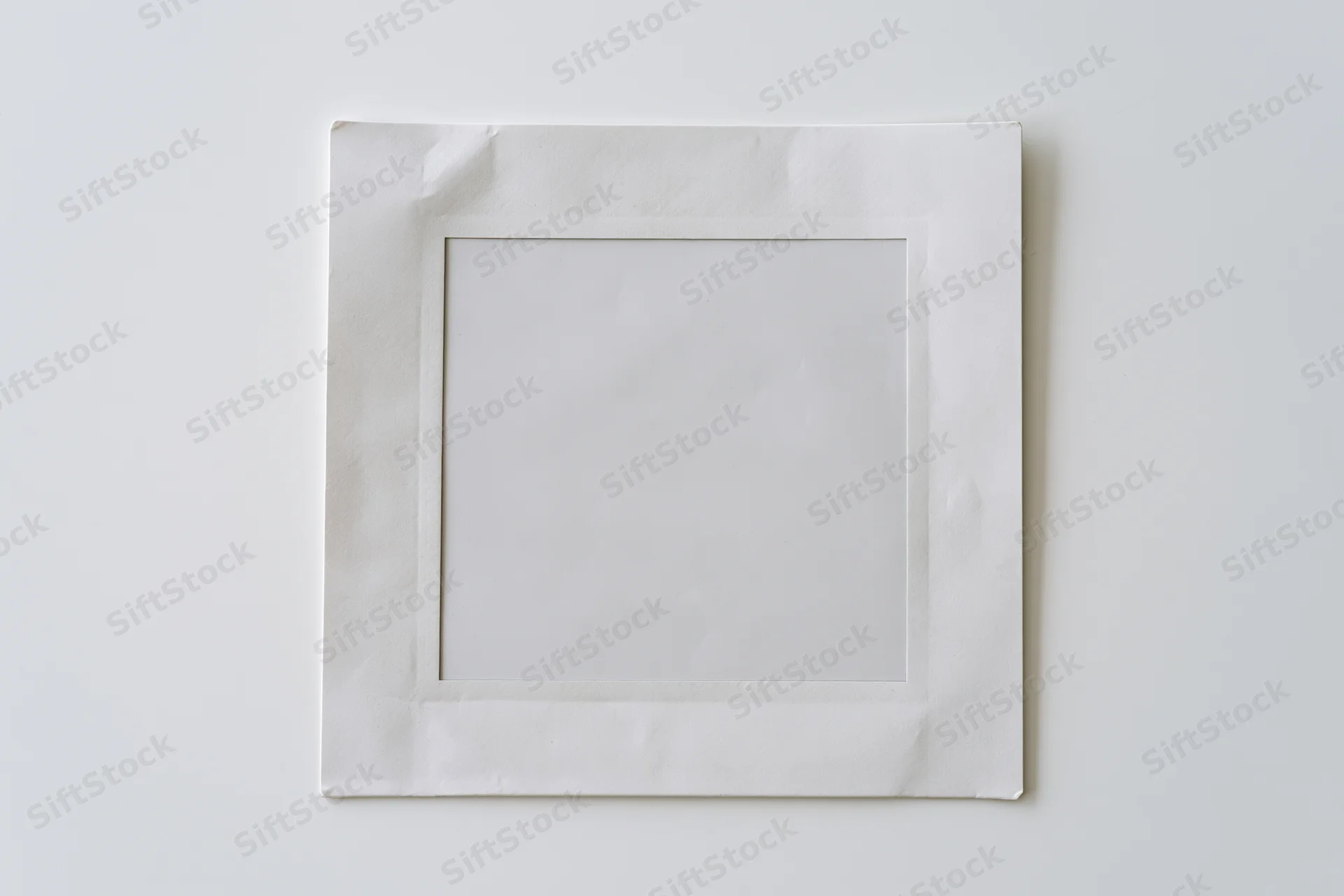 Blank instant film print lying flat on white surface