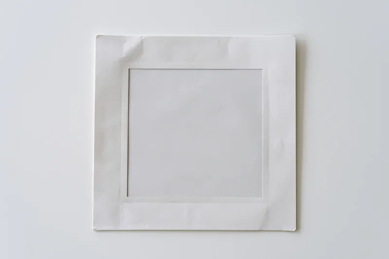 Blank instant film print lying flat on white surface