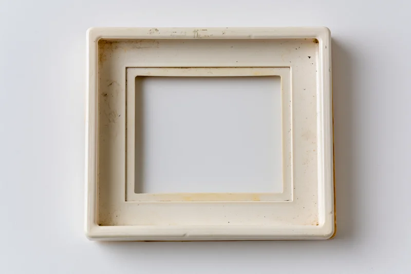 Vintage polaroid photo frame lying flat on white surface with visible wear and grime
