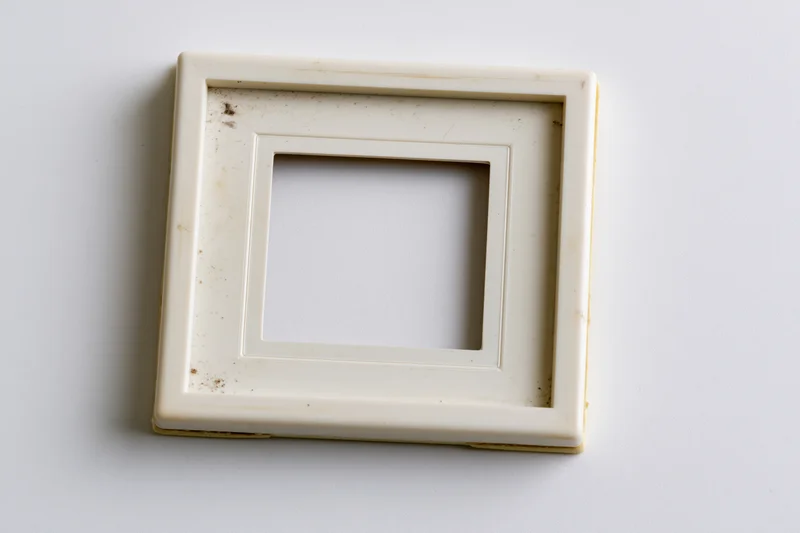 Vintage polaroid photo frame lying flat on white surface with visible stains and wear
