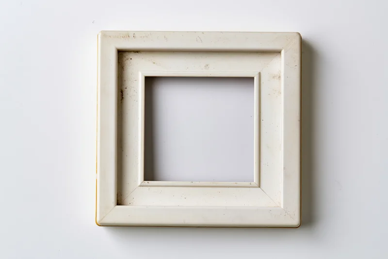 Vintage polaroid photo frame lying flat on white surface with empty center and distressed edges
