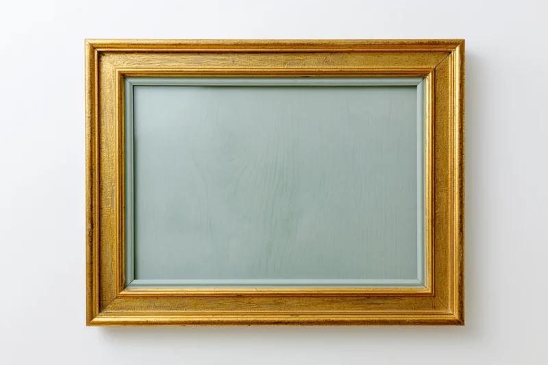 Gold rectangular frame hanging on white wall with empty glass front