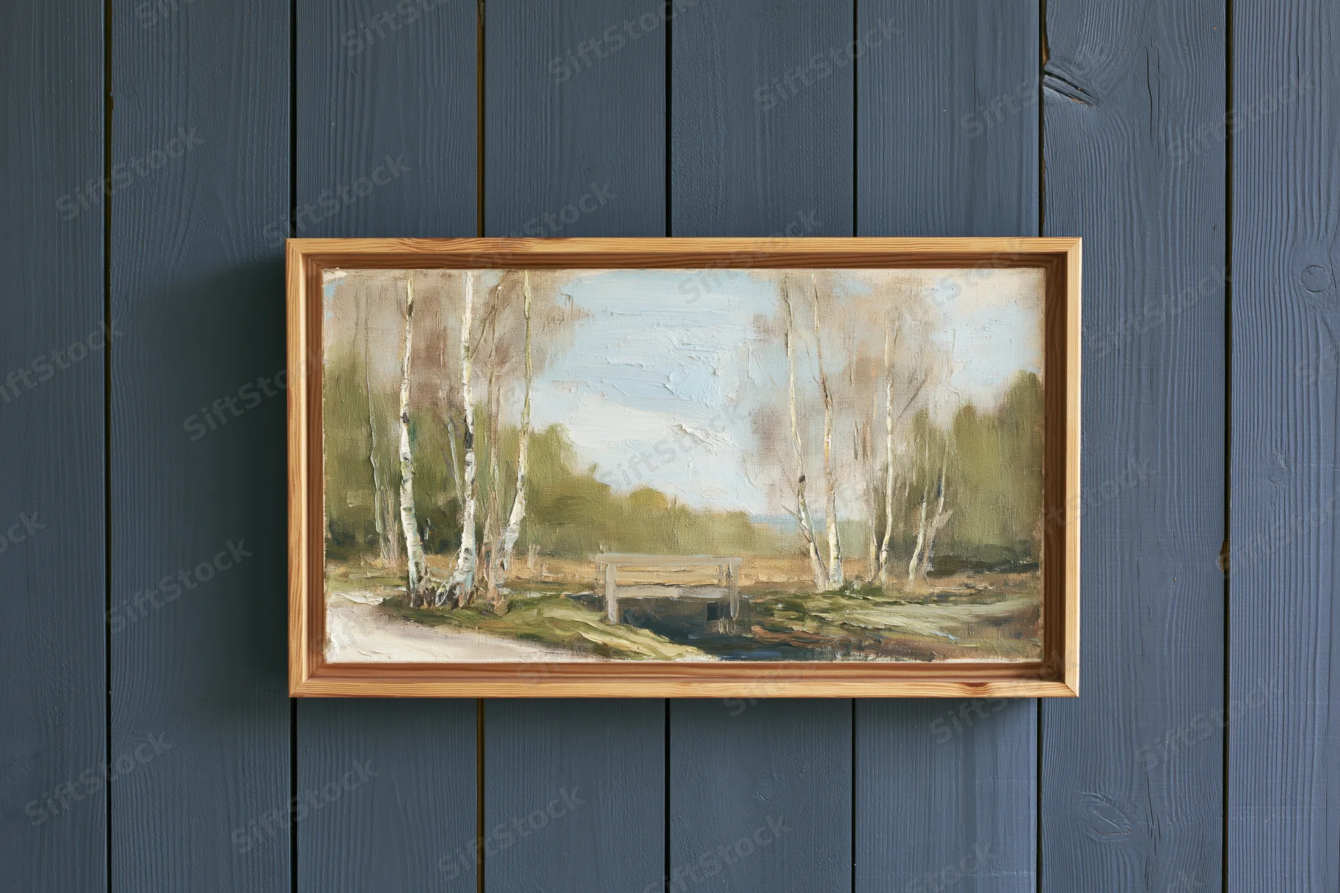 Framed oil painting of birch trees and a forest landscape hanging on a dark grey wooden wall