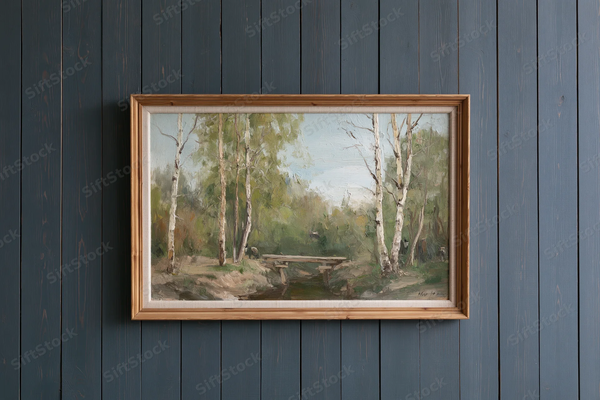 Framed oil painting of birch trees and a forest path hanging on a dark grey wooden wall