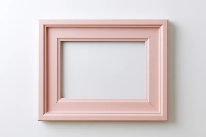 Pale pink wooden picture frame with simple molded edges hanging on white wall