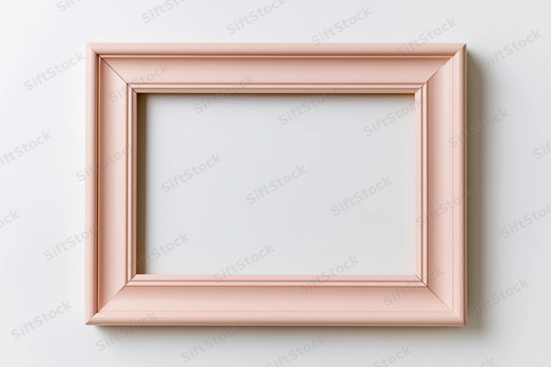 Pale pink wooden picture frame with simple molded edges hanging on a white wall