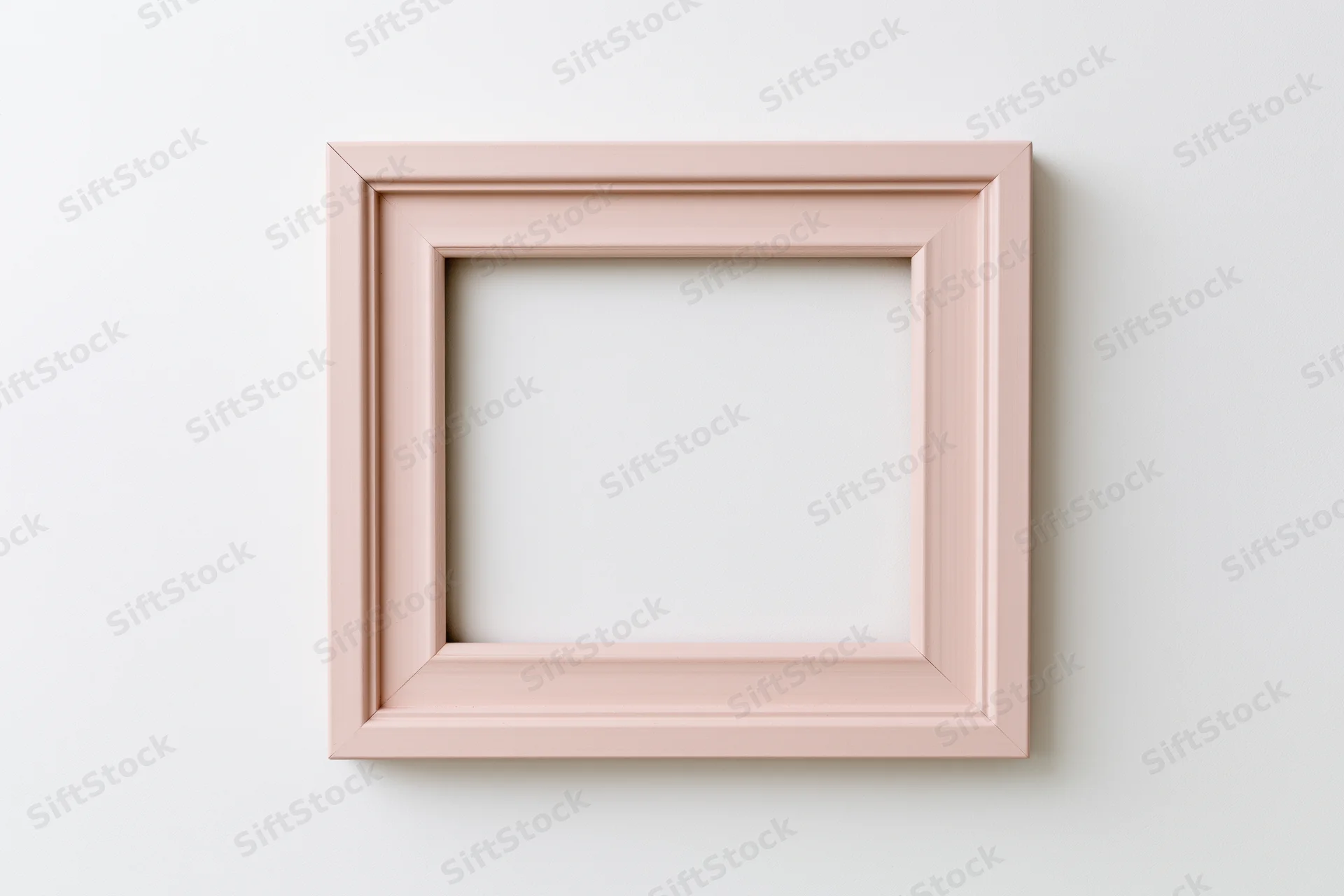 Pale pink wooden picture frame with simple molded edges hanging on a white wall