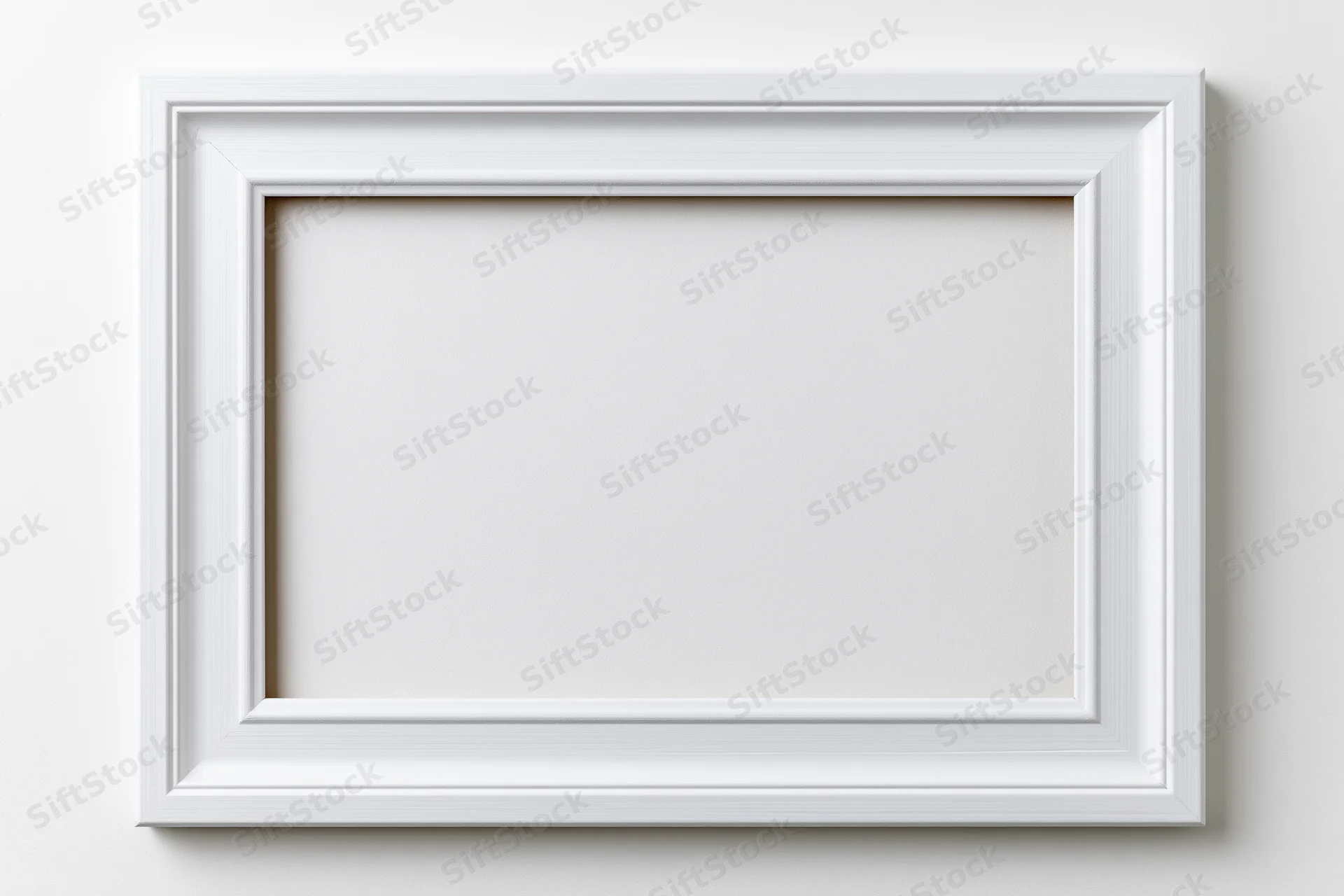 White wooden picture frame hanging on a plain wall with empty center for display