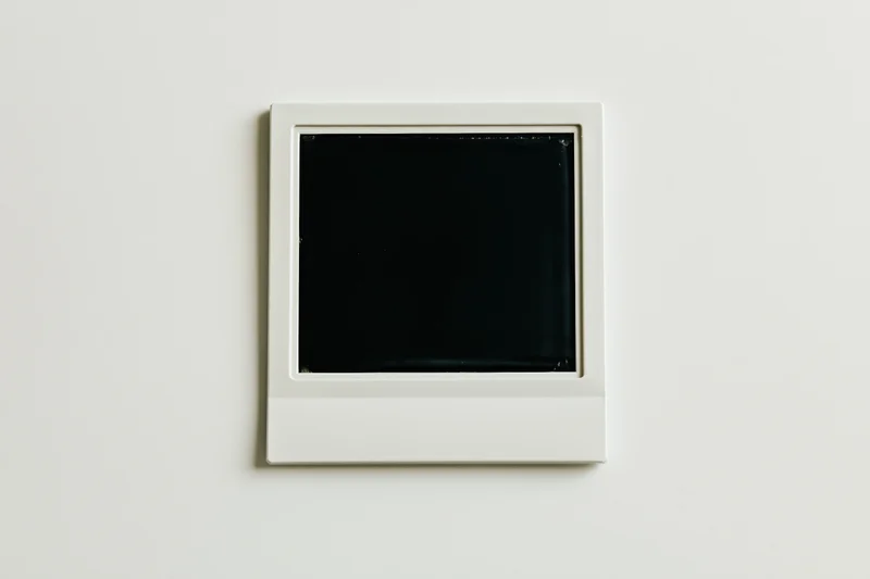 Blank polaroid instant photo print lying flat center on white surface