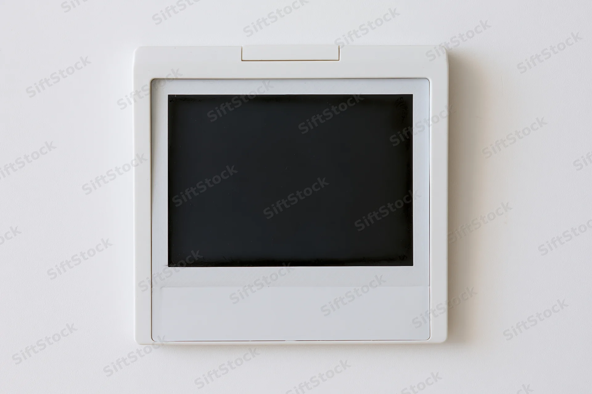 Blank polaroid instant photo print lying flat on white surface