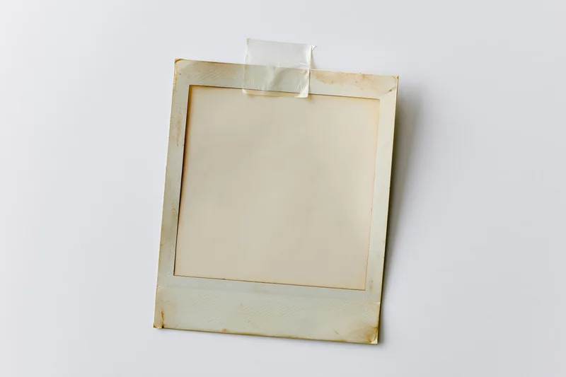Blank instant film photo print taped to white surface