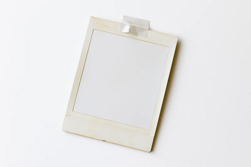 Blank instant photo print taped to white surface