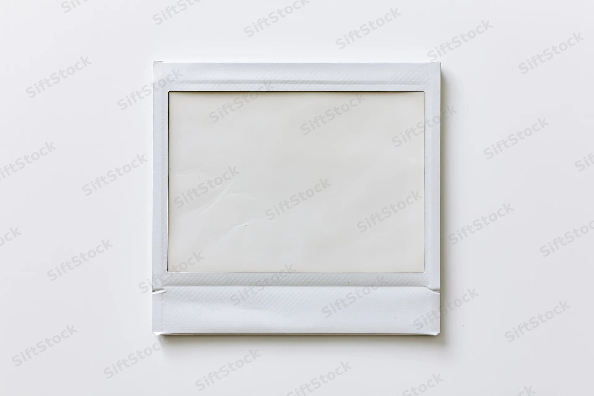 Blank instant photo print lying flat on white surface