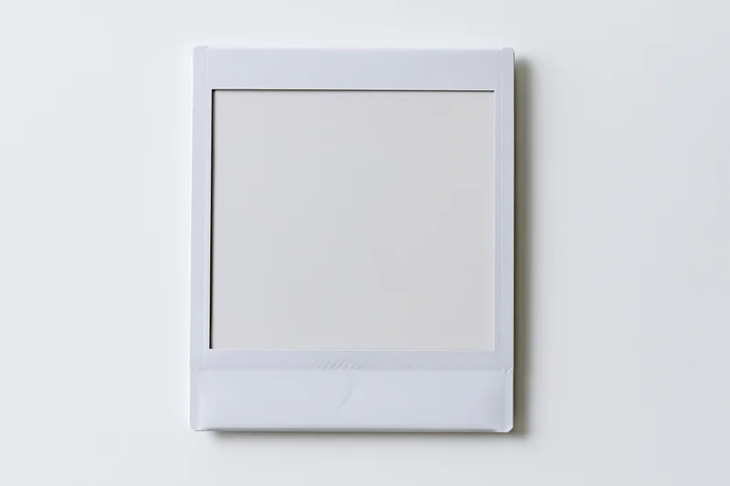 Blank instant photo print lying flat centered on white surface
