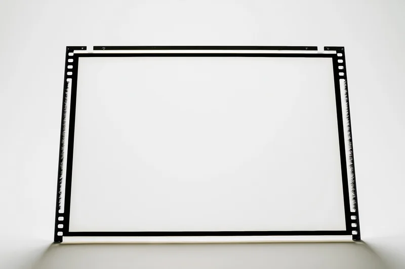 Blank medium format film frame standing upright on white surface