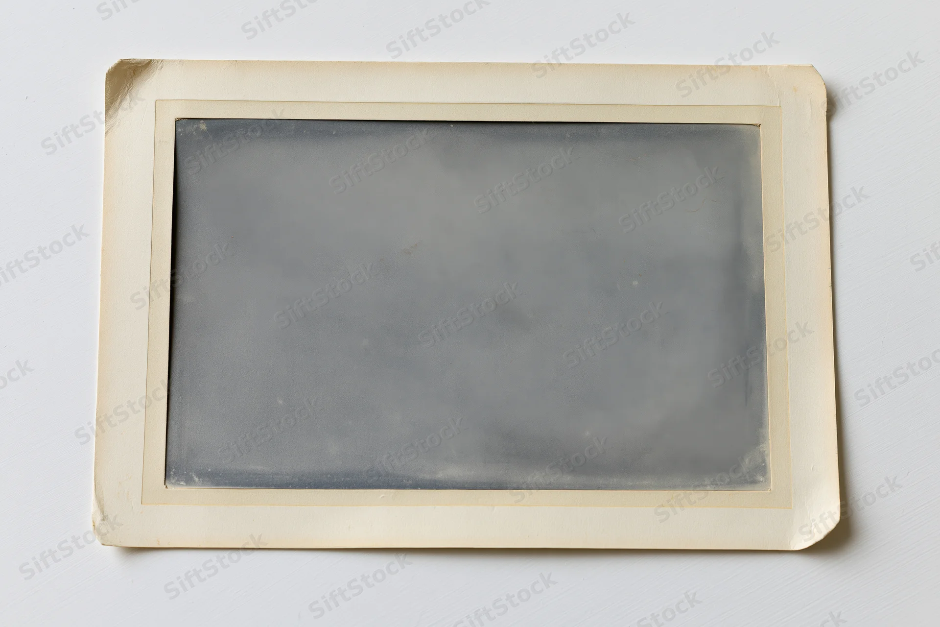 Vintage photograph print with aged paper border lying flat on white surface