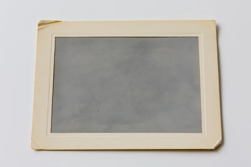 Vintage photograph print with aged paper frame lying flat on white surface