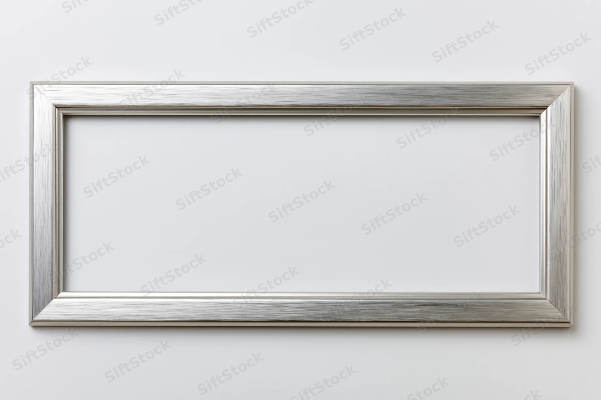 Silver brushed metallic rectangular picture frame mounted on white wall