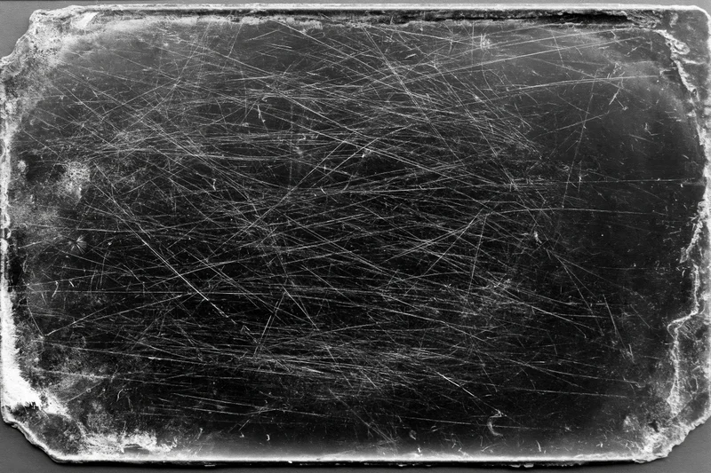 Heavily scratched and worn darkroom photographic paper with aged texture