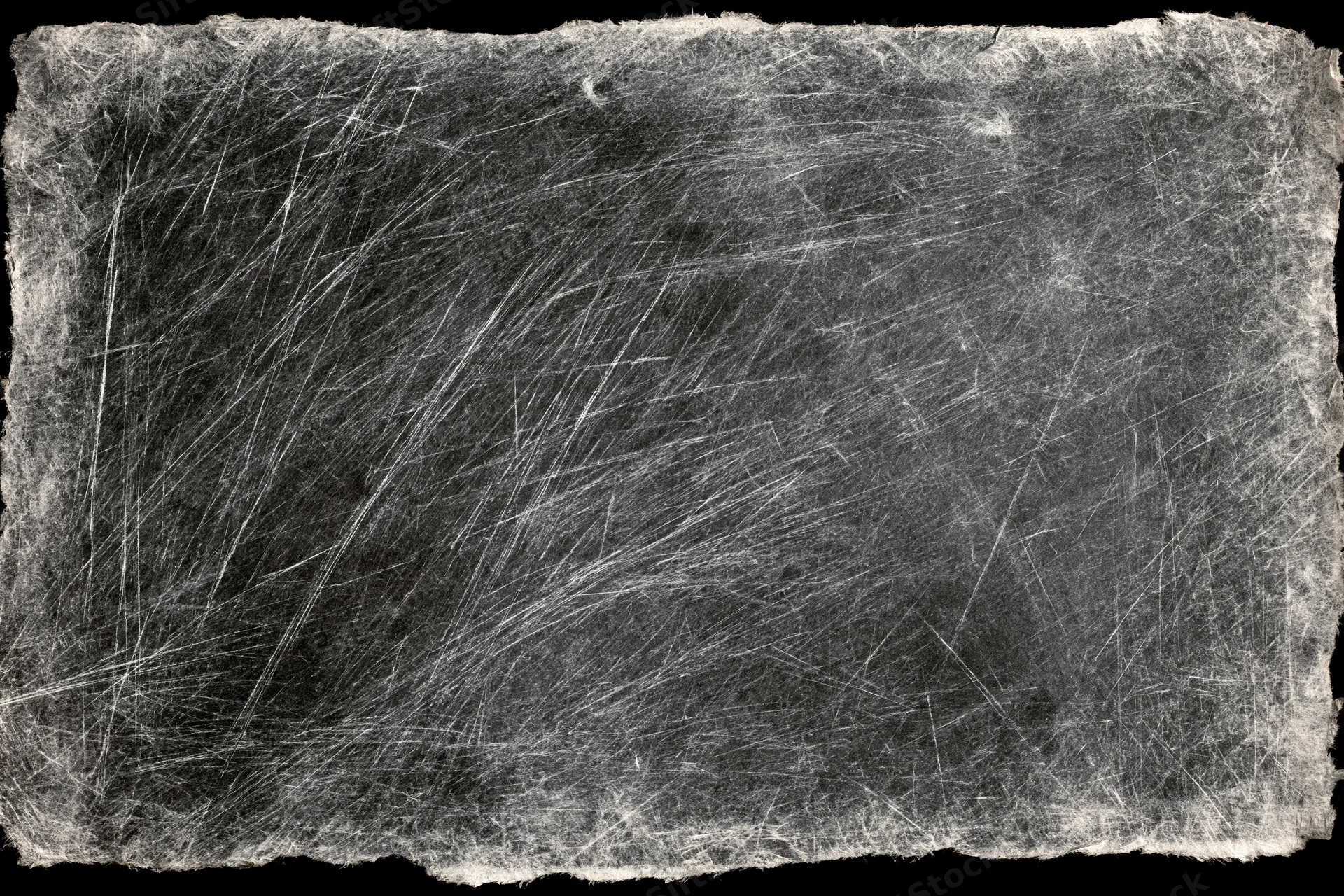 Heavily scratched and worn darkroom photographic paper with fibrous edges and monochrome texture