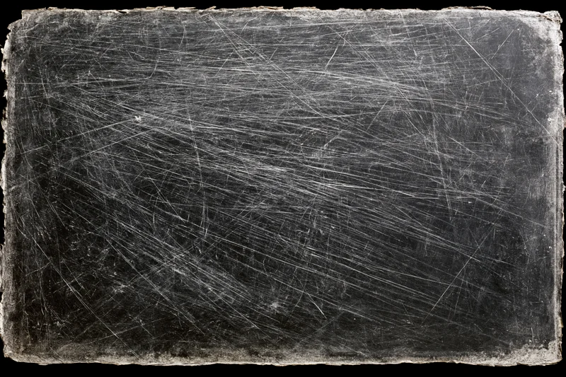 Heavily scratched and worn darkroom photographic paper with frayed edges