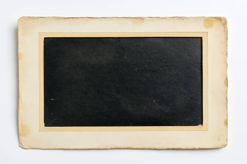 Old blank photographic print with aged paper border lying flat on white background