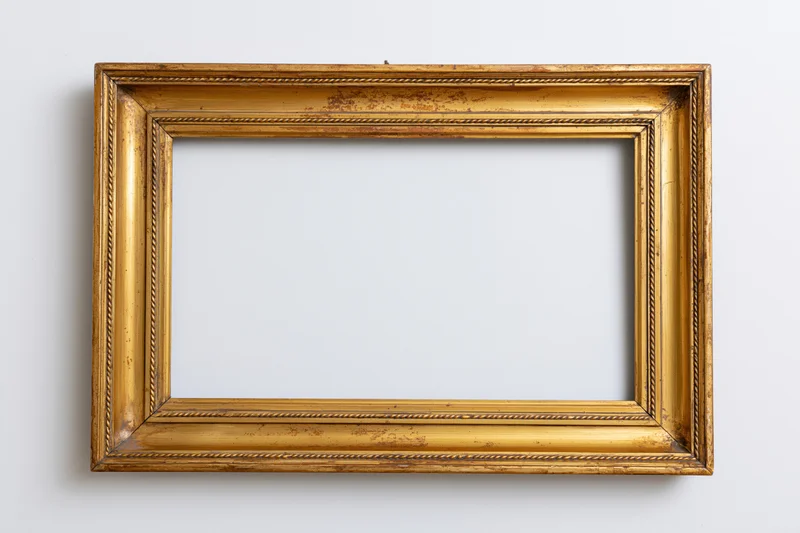 Ornate antique gold picture frame with empty interior hanging on white wall