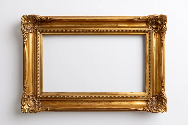 Ornate antique gold picture frame with carved floral corners hanging on white wall