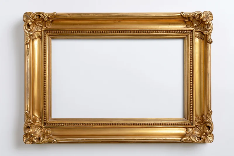 Ornate gold picture frame with carved floral corners hanging on white wall