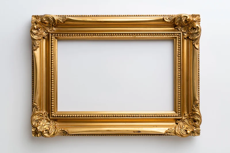 Ornate gold picture frame with carved floral corners hanging on white wall