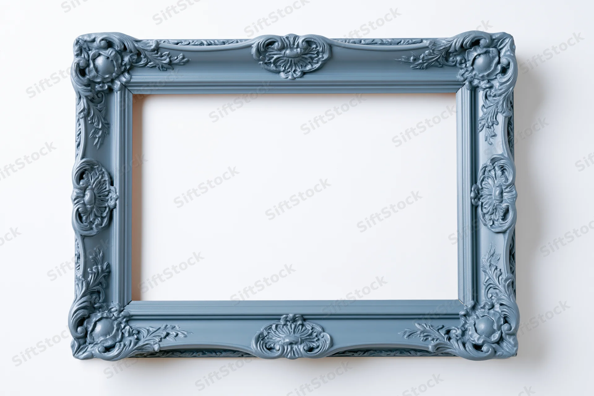 Ornate antique blue frame with carved floral details hanging on a white wall