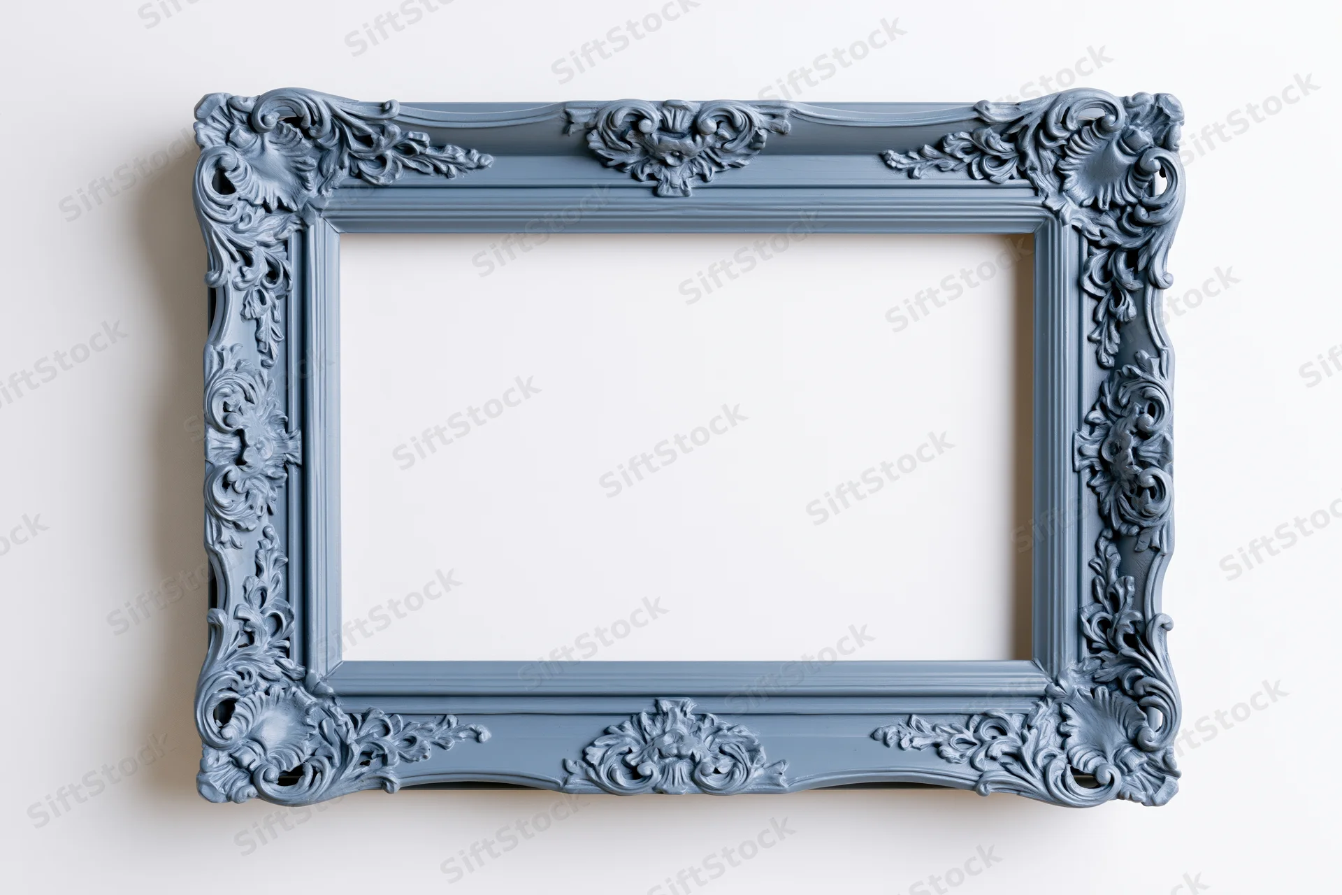 Ornate antique blue frame with floral carvings hanging on a white wall