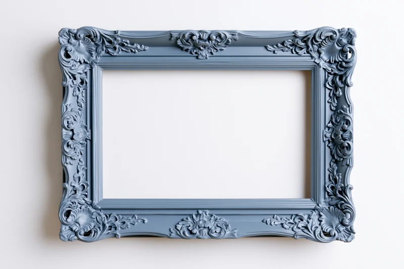 Ornate antique blue frame with floral carvings hanging on a white wall