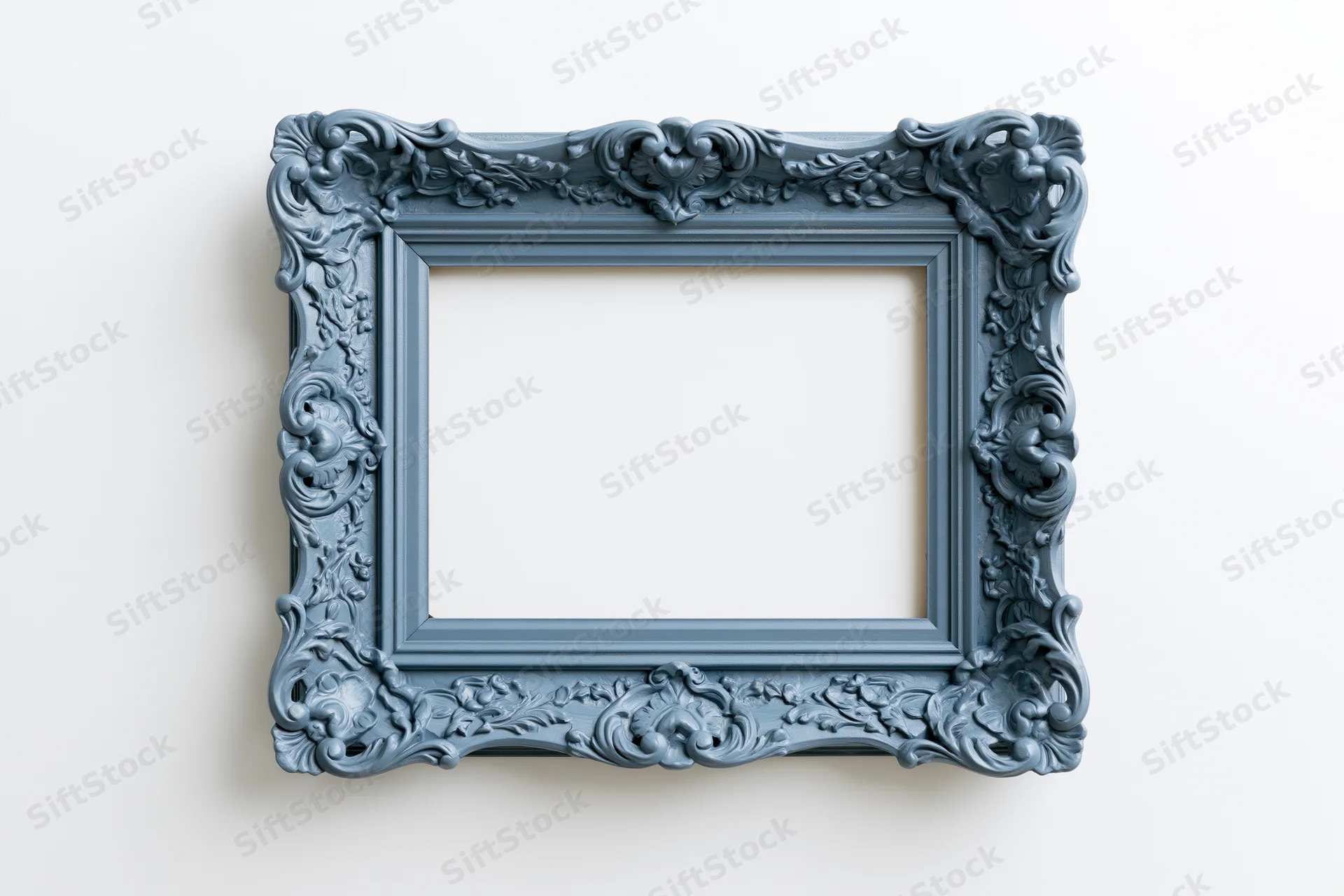 Ornate antique blue picture frame with intricate carvings hanging on a white wall
