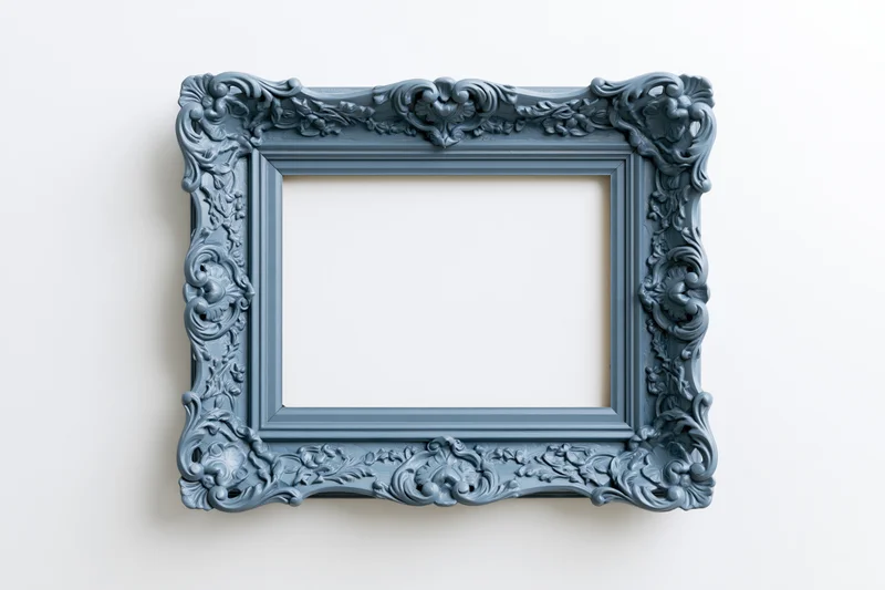 Ornate antique blue picture frame with intricate carvings hanging on a white wall