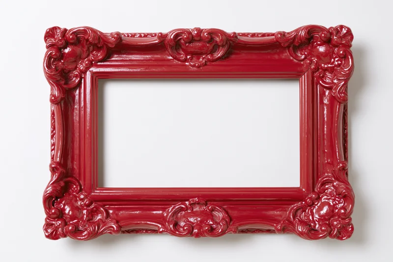 Ornate red baroque-style picture frame with glossy finish isolated on white background