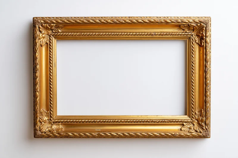 Ornate gold picture frame with carved leaf details hanging on white wall