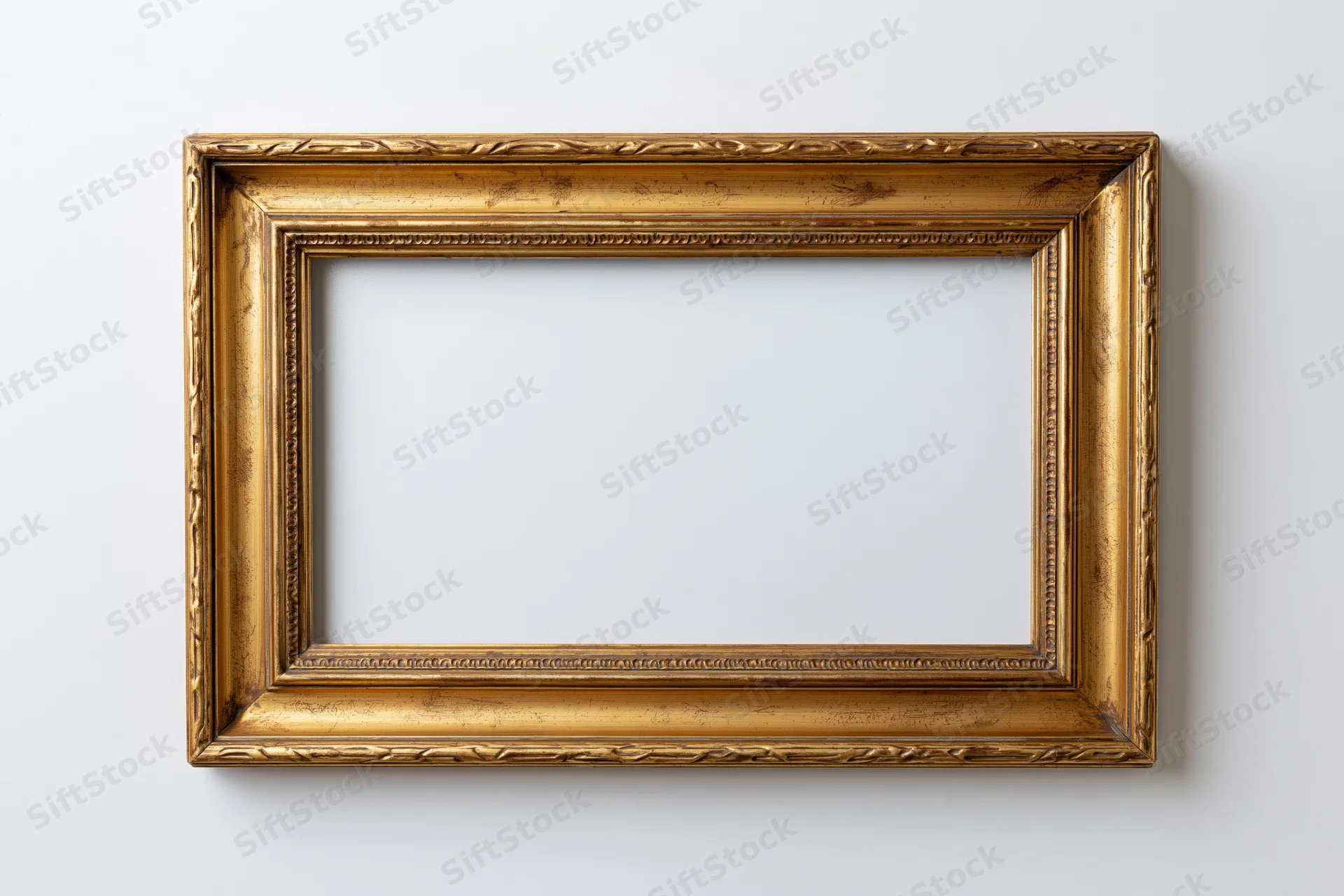 Ornate gold picture frame hanging on white wall with empty center for display